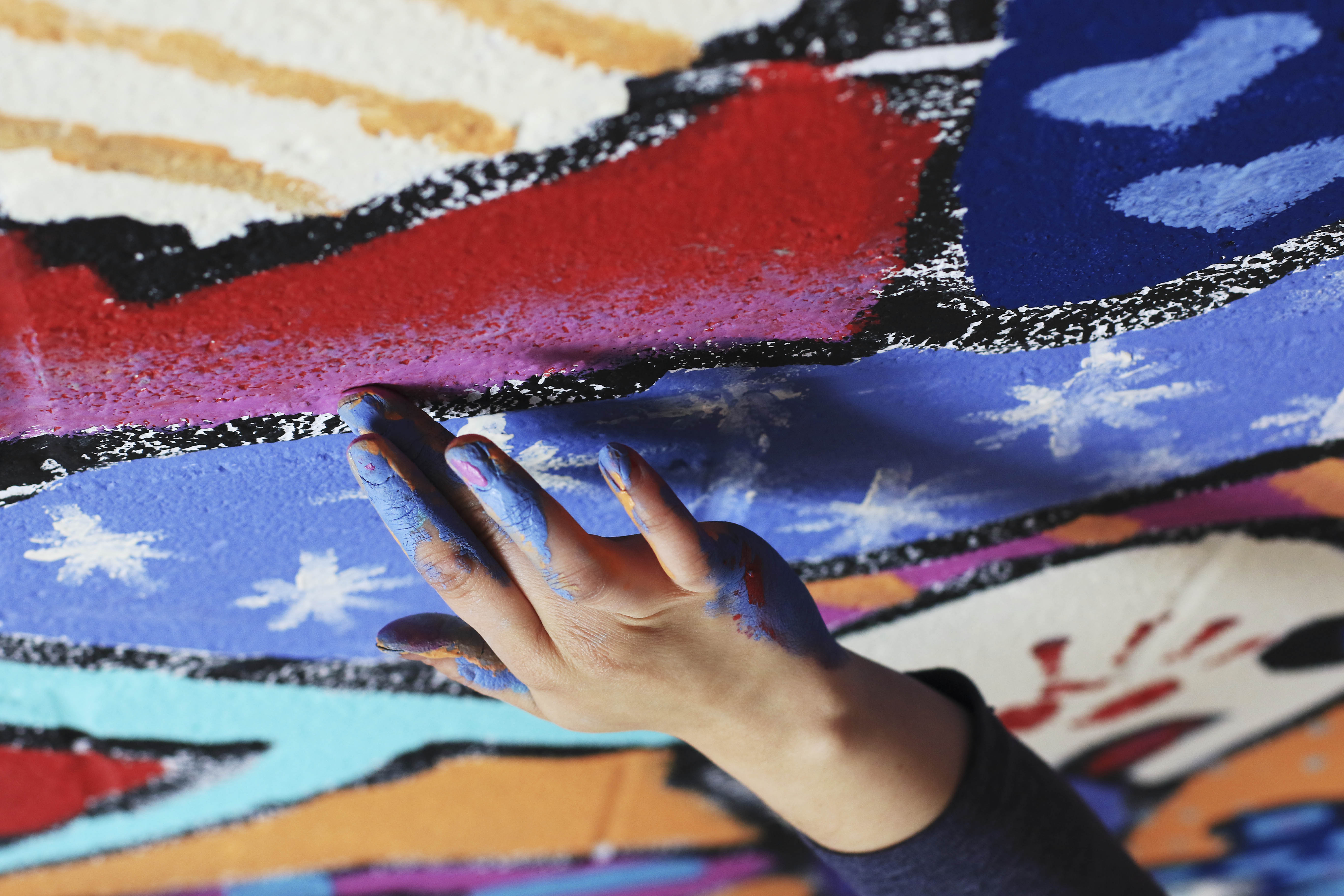 Rayleena Ceruz add more subtle details to the mural in the alley behind Out of the Blue Antiques in downtown Livingston on Tuesday afternoon.