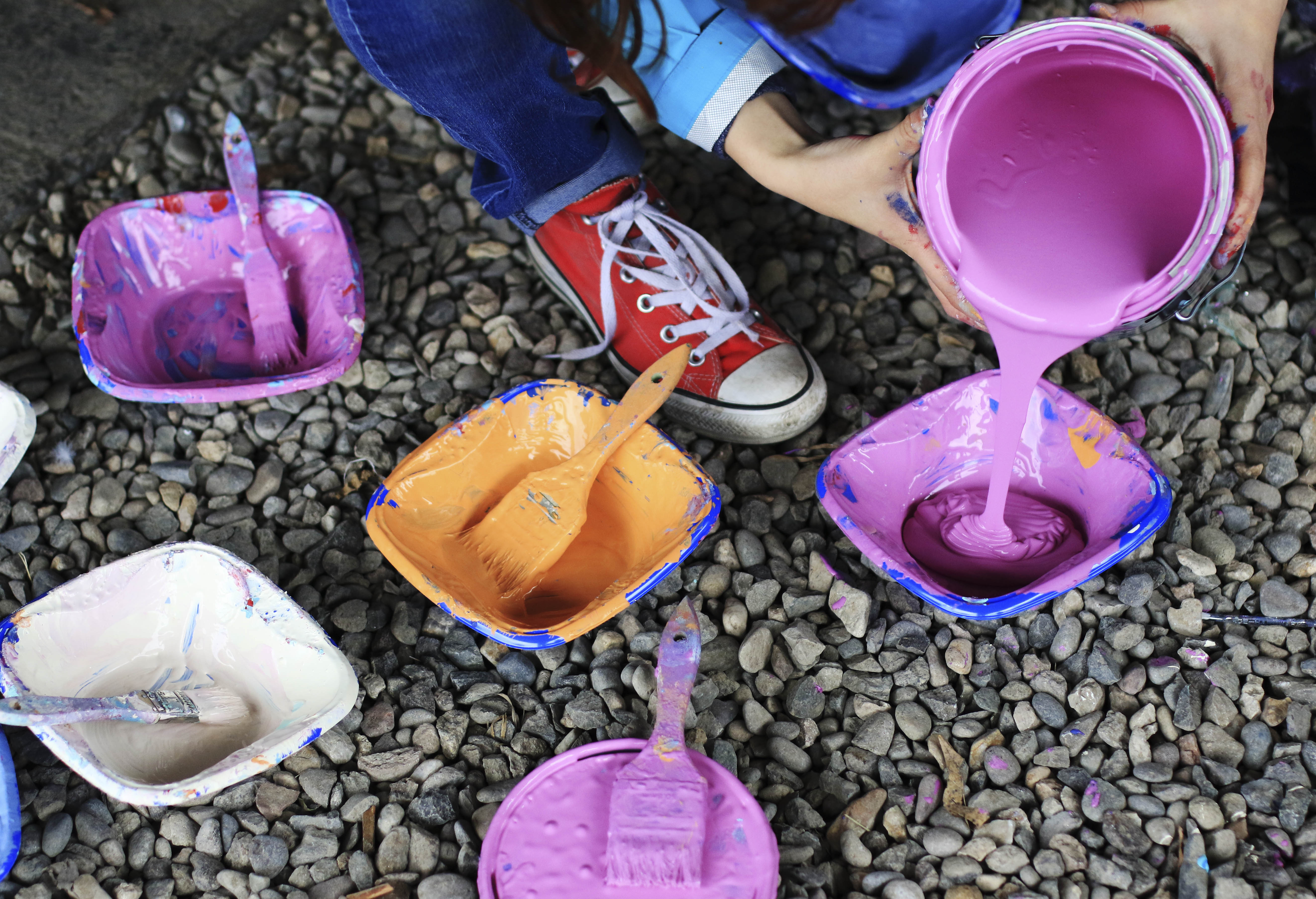 Park High School senior Kate Helin-Burnette pours more paint for the mural in the alley behind Out of the Blue Antiques on Tuesday afternoon. The project was guided by Tenesse artist Andee Rudloff